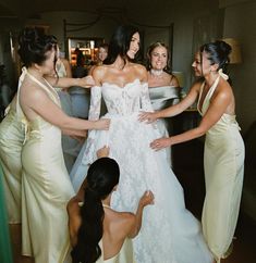 bridesmaids helping the bride get ready for her big day in gold gowns