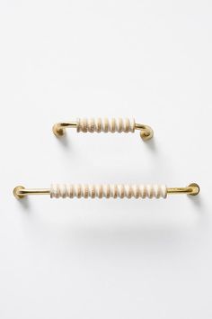 two white and gold colored handles on the back of a pair of hair pins,