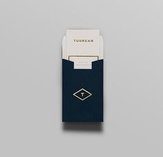 a business card holder with a gold logo on the front and blue paper in the back