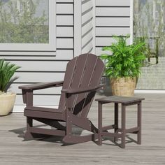 a wooden chair and table sitting on a porch next to a potted houseplant