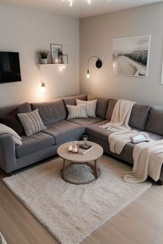 a living room with grey couches and white rugs on top of the floor