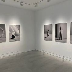 four black and white photographs hanging on the wall in an empty room with no people