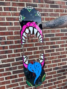 a man holding up a skateboard shaped like a shark