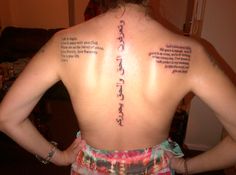 the back of a woman's body with writing on her upper and lower back