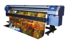 an image of a large plot printer with autumn trees in the background and water on it