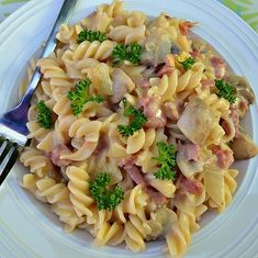 bacon and mushroom pasta on a plate with a fork