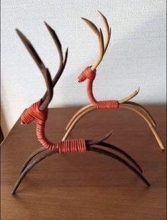 two metal deer sculptures sitting on top of a wooden table