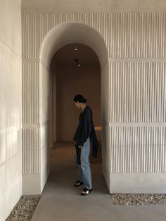 a man standing in an archway between two walls, with his back to the camera