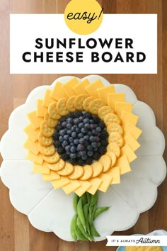 a sunflower cheese board with grapes and crackers in the center on a white plate