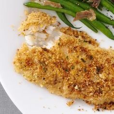 a white plate topped with fish and green beans