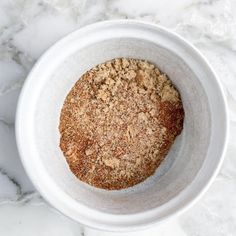 a white bowl filled with food on top of a marble counter