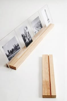 a wooden block with four photos in it and a piece of wood on the ground