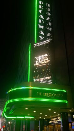 the neon sign on the side of a building is lit up in green and white