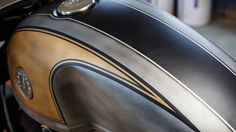 the front end of a motorcycle with a black and gold stripe on it's side