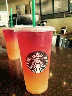 two drinks sitting on top of a table next to each other in front of a counter