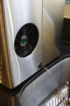 a stainless steel sink with a ventilator on the side