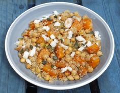 a white bowl filled with food on top of a wooden table