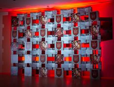 a wall with red lights behind it and some pictures on the wall in front of it