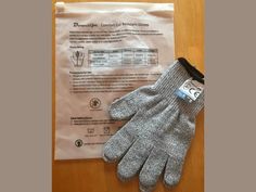 two gloves are laying on the table next to an envelope with instructions for how to use them