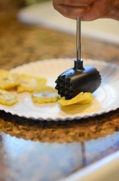 a person is using a knife to cut bananas on a plate