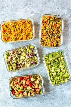 four plastic containers filled with different types of salads on a gray table top next to each other