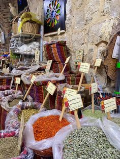 an outdoor market with lots of different types of spices and herbs for sale in bags