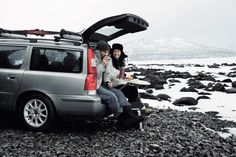 two people sitting in the back of a van