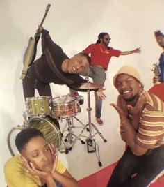 three men are posing for a photo in front of musical instruments and drum sticks,