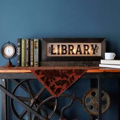 a book shelf with books on it and a clock next to it that says library