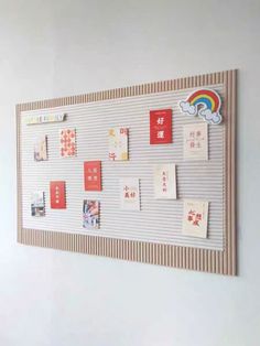 a bulletin board with post - it notes attached to the wall and rainbow on top