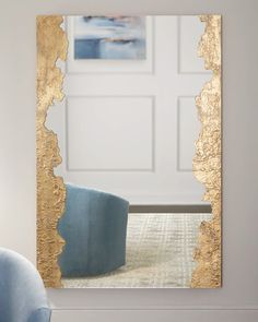 a mirror that is sitting on top of a table in front of a blue chair