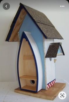 a bird house with a blue roof and white walls