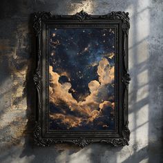 a painting hanging on the wall in front of a window with an image of clouds and stars