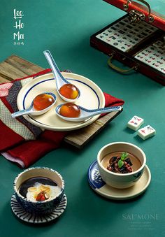 two bowls of soup are sitting on a table with other dishes and utensils