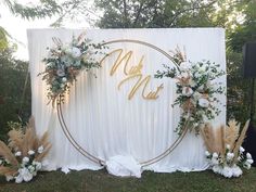 a white backdrop with gold lettering and flowers