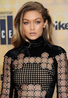 a woman with blonde hair wearing a black dress and choker on the red carpet