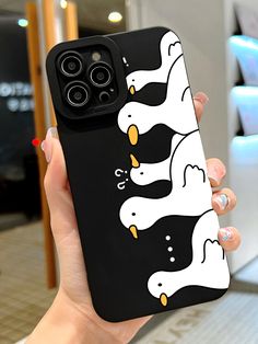 a person holding up a phone case with two penguins on it