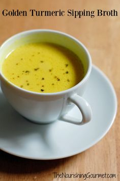 a cup of golden turment sitting on top of a white saucer