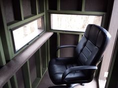 an office chair sitting next to a window in a room with green paneled walls