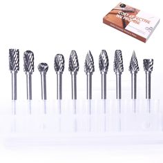 seven diamond drill bits are lined up in a row with the box next to them