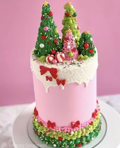 a pink cake decorated with christmas trees and candy