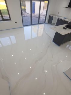 a kitchen with white marble floors and cabinets