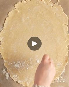 a person is kneading dough on a table with a video screen in front of them