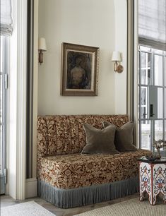 a living room filled with furniture and windows next to a painting hanging on the wall