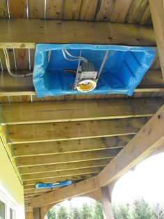 the inside of a covered patio area with a blue cover over it and an object hanging from the ceiling