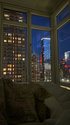 a bedroom with a view of the city at night