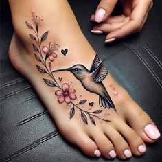 a woman's foot with a hummingbird and flowers on it