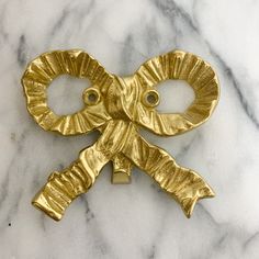 an elephant shaped brooch sitting on top of a marble counter next to a pair of scissors