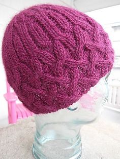 a purple knitted hat sitting on top of a head