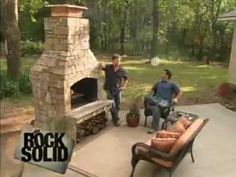 two men are playing frisbee in front of an outdoor fireplace